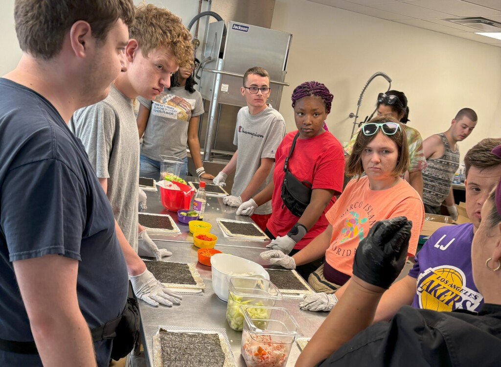 Students listen closely to a cooking lesson. 